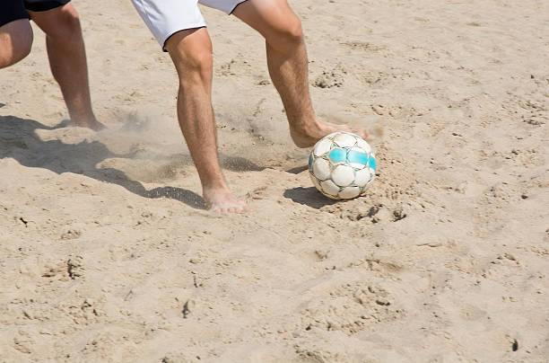 Leisure, holidays, people and sport concept - happy friends playing football at summer time
