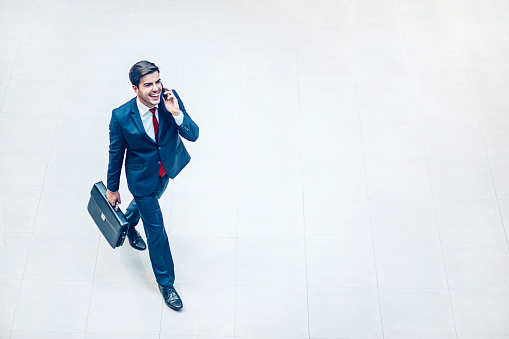 Young businessman smiling indoors, top view with copy space