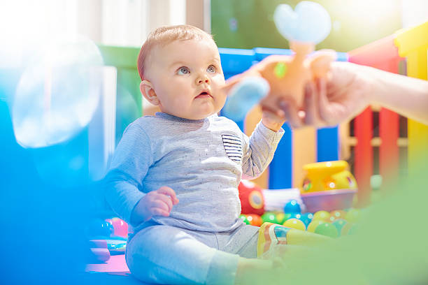 istock Young baby boy playing with mother in playpen 497940074