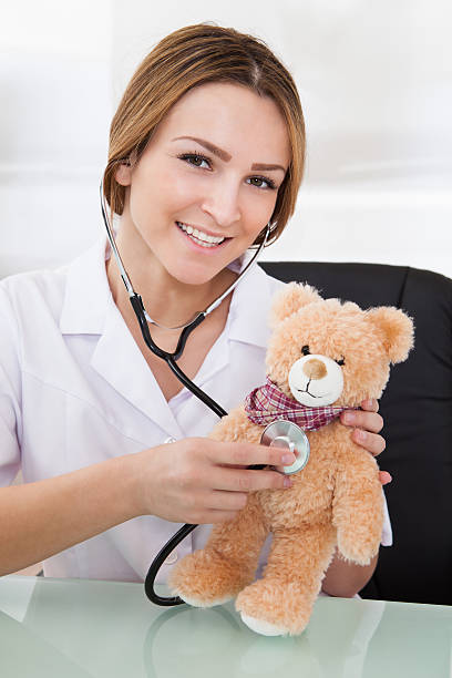 istock Female Doctor Examining Teddy Bear 497940352