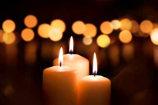 Three candles on dark background