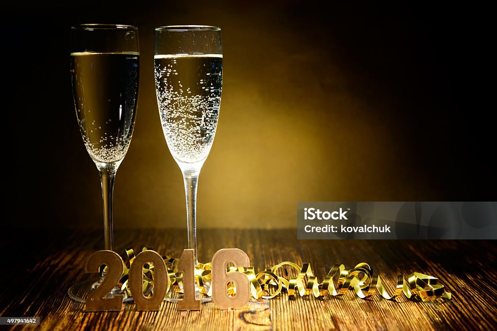 Two glasses of champagne and gold figures 2016 Two glasses of champagne and gold figures 2016 on a wooden background 2015 Stock Photo
