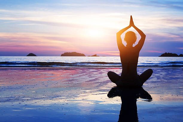 istock woman meditating on the beach 497942740