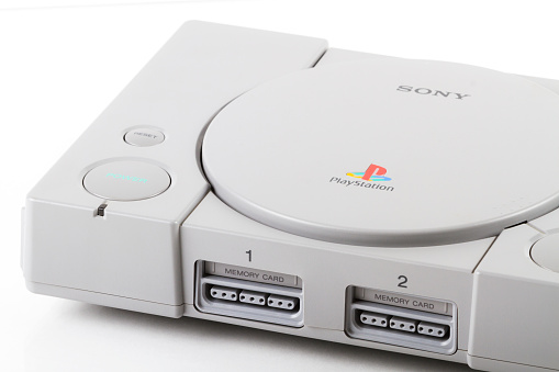 Calgary, Canada - July 4, 2011: Front view product shot of a Sony PlayStation 2 video game console, sitting on a reflective surface and isolated against a white background.