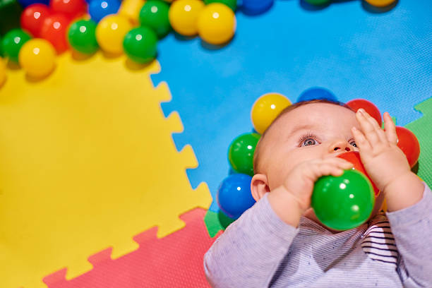 istock Baby boy plays in his playpen with plastic balls 497946976