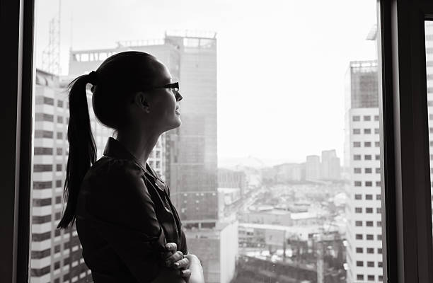 donna d'affari guardando fuori la finestra - looking through window window business women foto e immagini stock