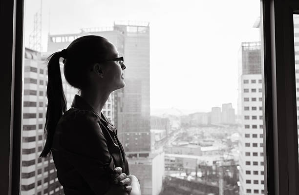 Businesswoman looking out the window Businesswoman looking out the window. manhattan new york city photos stock pictures, royalty-free photos & images