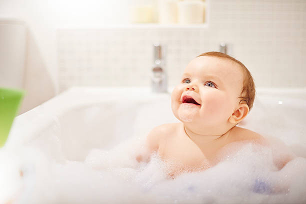 istock Baby boy laughing in his bubble filled bath 497947216