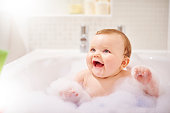 Baby boy laughing in his bubble filled bath