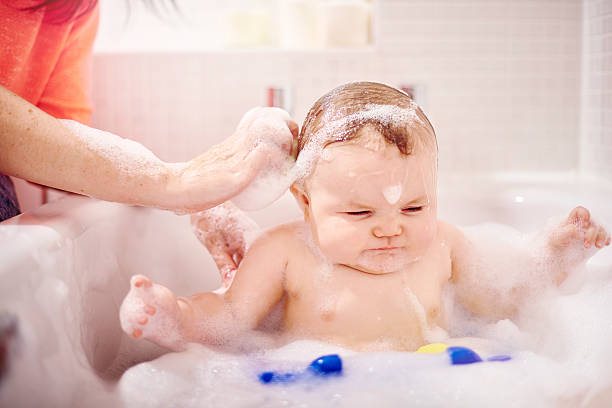 istock Baby boy sat in the bath having his hair washed 497947494