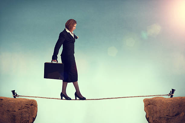 istock businesswoman balancing on a tightrope 497950285