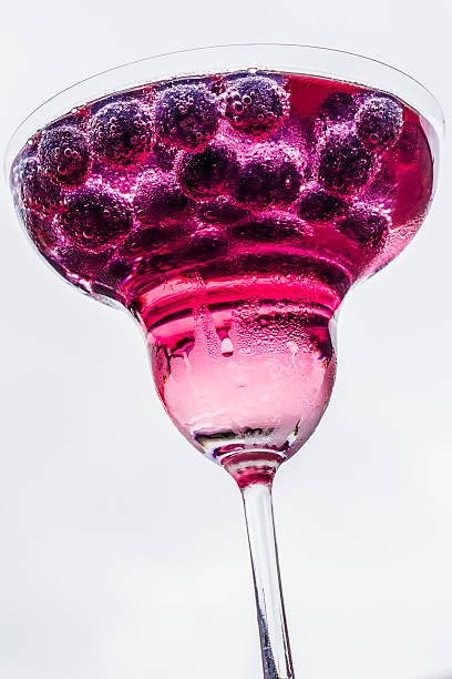Pink cocktail with fruit in margarita glass