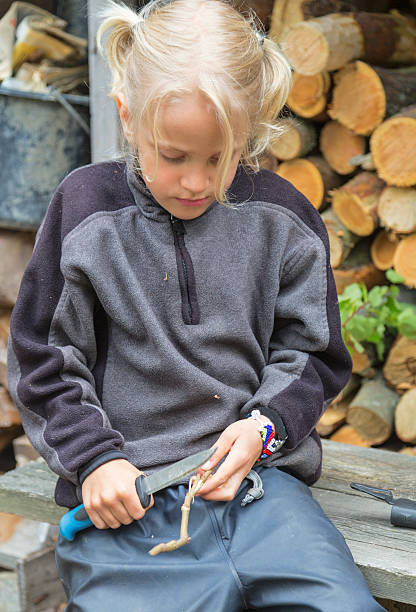 istock Little blond boy carving with knife. 497951137