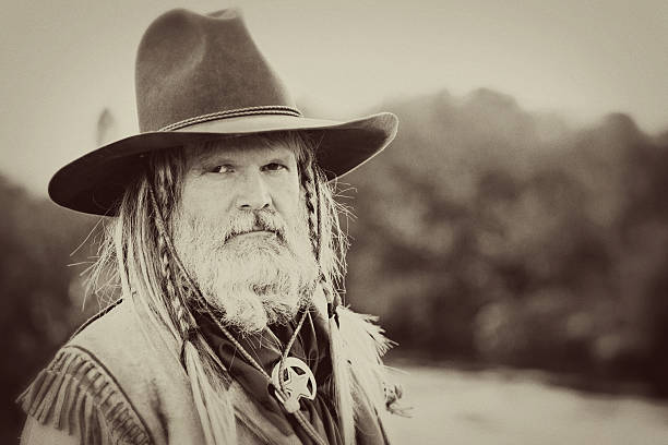 Vintage portrait of a prospecting mountain man in period dress formally posing by a stream. Grain and vintage processing added. Taken at the Alien Cowboy Stampede.