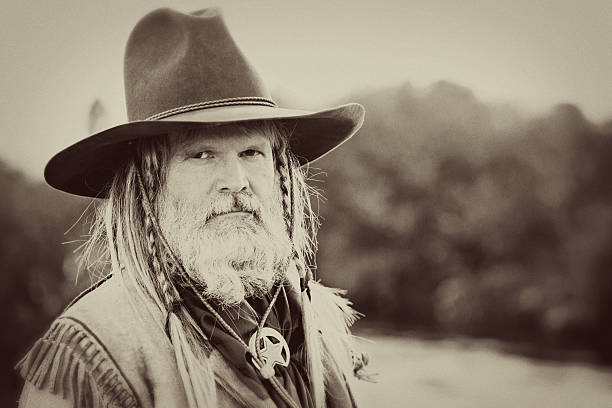 Portrait of A Mountain Man Vintage portrait of a prospecting mountain man in period dress formally posing by a stream. Grain and vintage processing added. Taken at the Alien Cowboy Stampede. panning for gold photos stock pictures, royalty-free photos & images