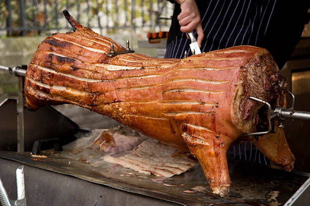 schweinebraten - pig roasted spit roasted domestic pig stock-fotos und bilder