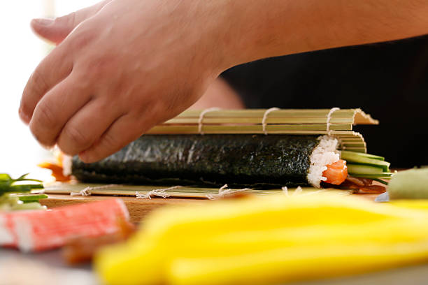 istock Sushi master prepares futomaki 497960702