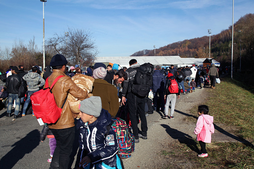 Sintilj, Slovenia - November 19, 2015:  Refugees and migrants wait to enter the Slovenian transit camp at the Austrian border. Countries along the Balkan refugee route, including Slovenia, are now restricting entry to refugees who can prove they are from Syria, Afghanistan, or Iraq.