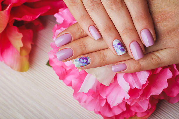 istock Lilac nail art with printed flowers on light background 497965386