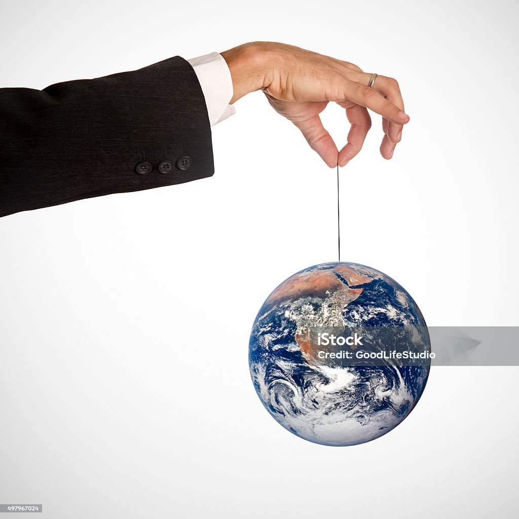 Earth hanging Earth globe seen from space balanced on thread held by a unrecognizable Caucasian businessman (Global business or environment crisis concept). 2015 Stock Photo