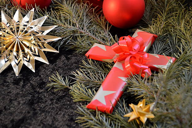 cross wrapped in paper as a present at Christmas day as a symbol, that Jesus was not born to live at earth as a wealthy king, but to die for our sins.
