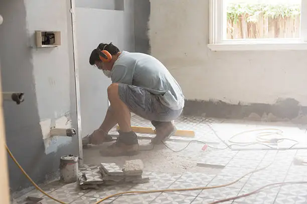 Grinding the bathroom floor in preparation for tiling during a home renovation in Sydney Australia