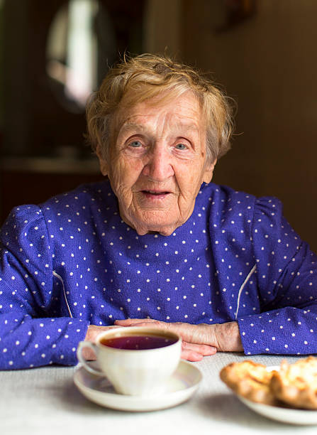 istock Portrait of an old granny drinks black tea at table. 497971328