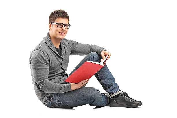 istock Happy guy reading a book seated on the floor 497978135