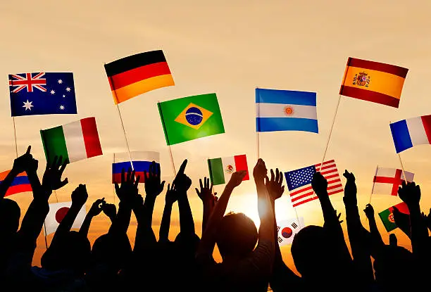 Photo of Silhouetted people holding various country flags