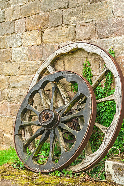 istock Old Wooden Wheels by Old Stone Wall 497980623