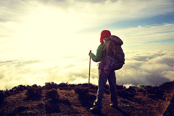 istock young woman backpacker at sunrise mountain peak 497982726