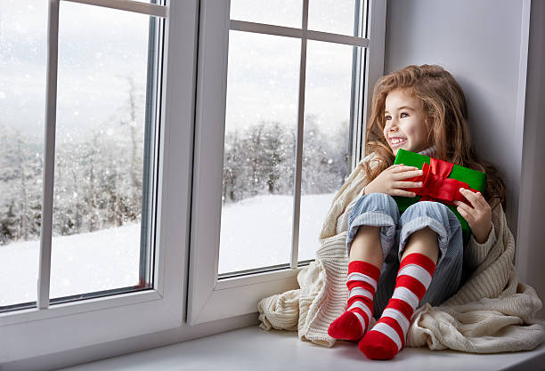 istock little girl sitting by the window 497983472