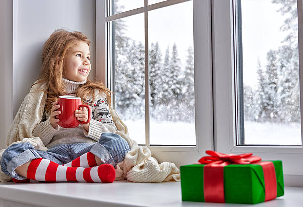 istock little girl sitting by the window 497984118