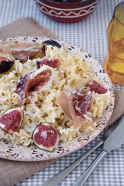 Pasta ribbons with ham and figs stock photo