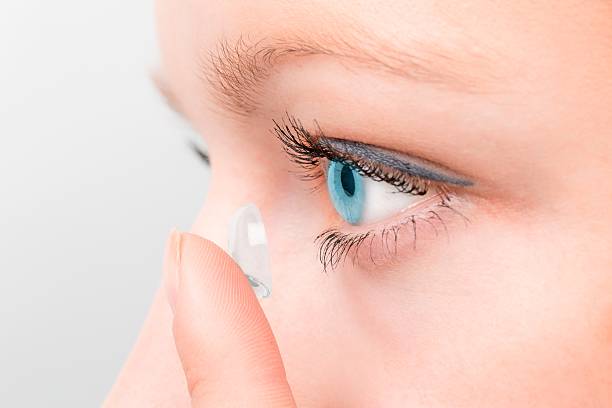istock Woman inserting a contact lens in eye. 497986082