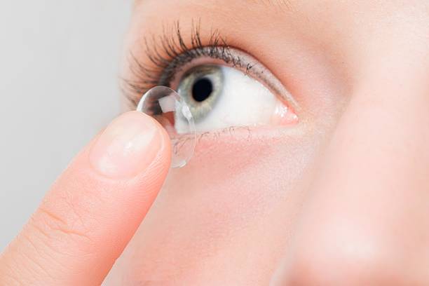 istock Woman inserting a contact lens in eye. 497986176