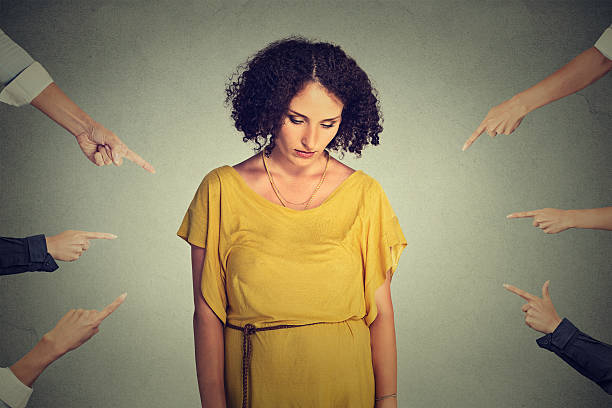 istock Accusation sad embarrassed woman looking down fingers pointing at her 497988544