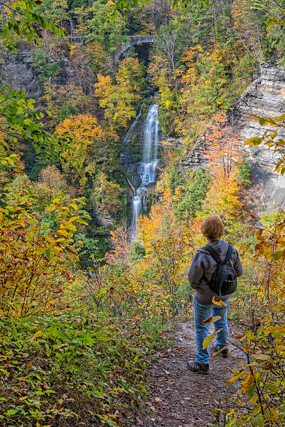 Enjoying The Autumn Colors Of Letchworth State Park Hiker Enjoying The View Of Deh-Ga-Ya-Soh Falls At Letchworth State Park In New York letchworth state park stock pictures, royalty-free photos & images