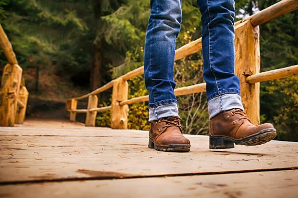 istock Woman in boots and blue jeans walks in park 497991044