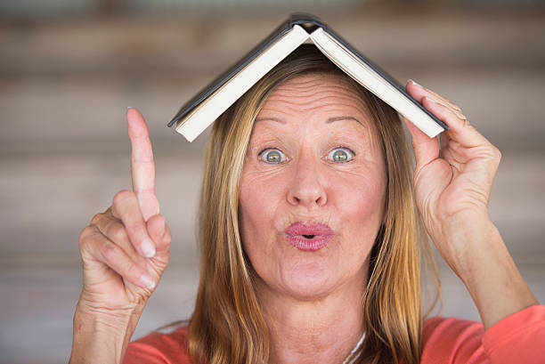istock Smart woman with book on head and idea 497991708