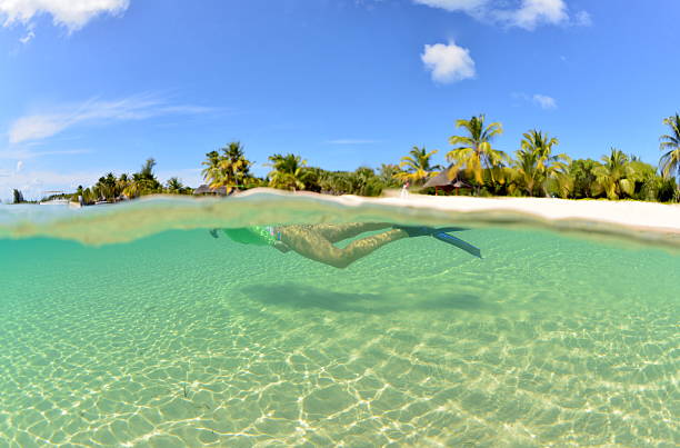 Snorkeling magic. A girl swims in the beautiful Indian Ocean while you can see one of the Bazaruto Archipelago islands behind her. mozambique stock pictures, royalty-free photos & images