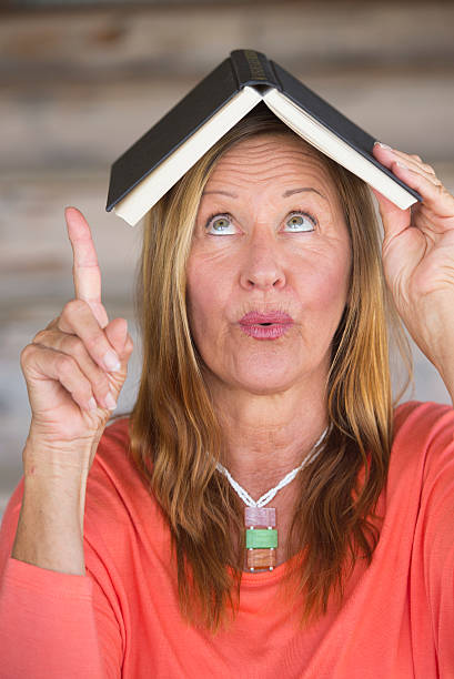 istock Portrait creative woman with book on head 497992152