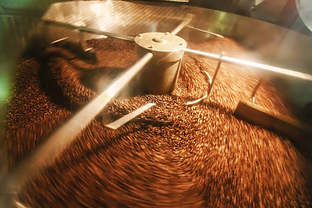 recién tostado de granos de café en un de los principales tostadores de café - roasted machine bean mixing fotografías e imágenes de stock