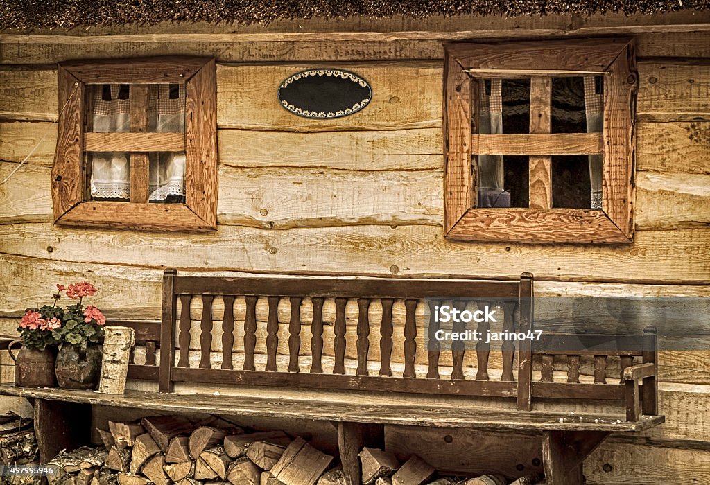 Bench in front of cottage Bench in front of wooden cottage 2015 Stock Photo