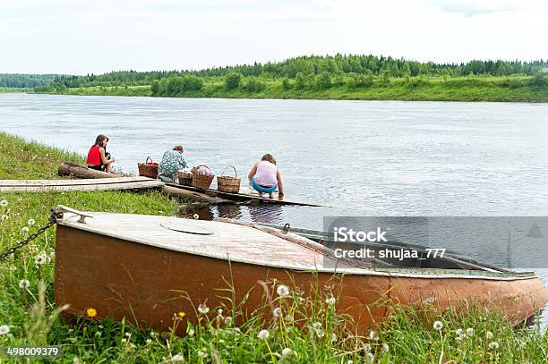 Woman With Daughters Squatting On Gangway Rinse Washing In River Stock Photo - Download Image Now