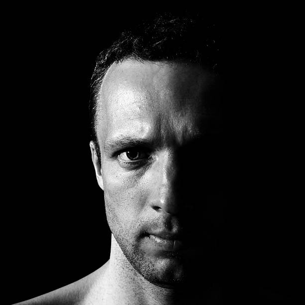 istock Young serious Caucasian man closeup portrait on black background 498009603