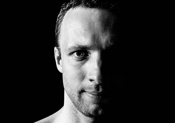 istock Young smiling Caucasian man closeup portrait on black background 498009605