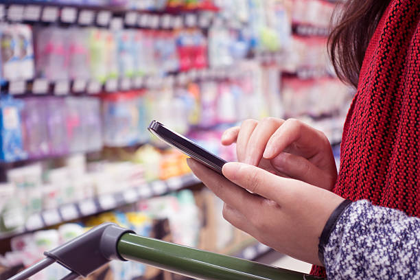 istock Woman using cellphone in supermarket 498013474
