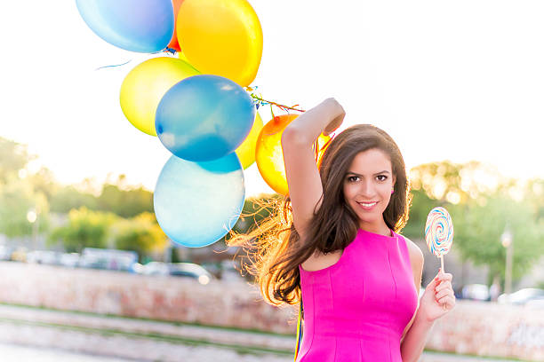 istock Woman with balloons and lollipop 498016711
