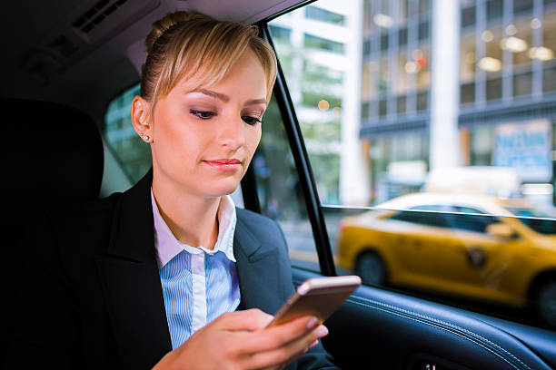 istock Business woman checking phone in car 498019424